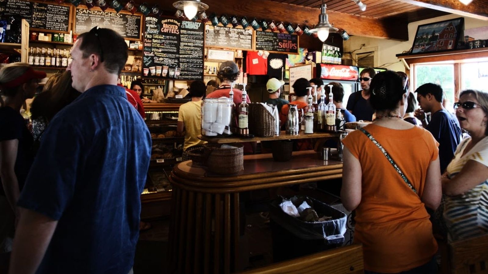 a group of people are standing in line at a restaurant .