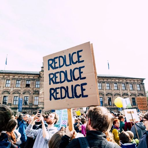 a group of people are holding a sign that says `` reduce reduce reduce '' .
