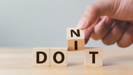 a person is stacking wooden blocks with the word do it written on them .