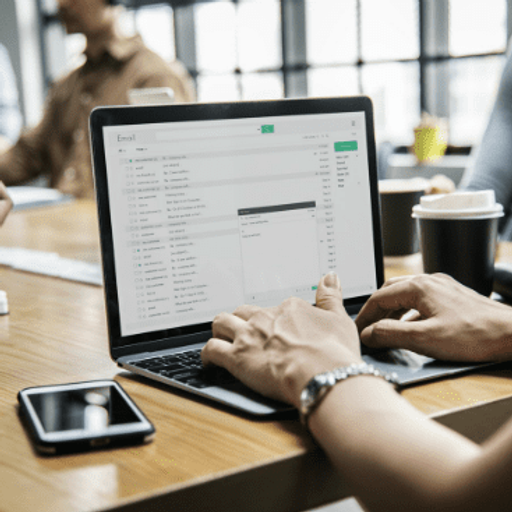 a person is typing on a laptop that says email on the screen