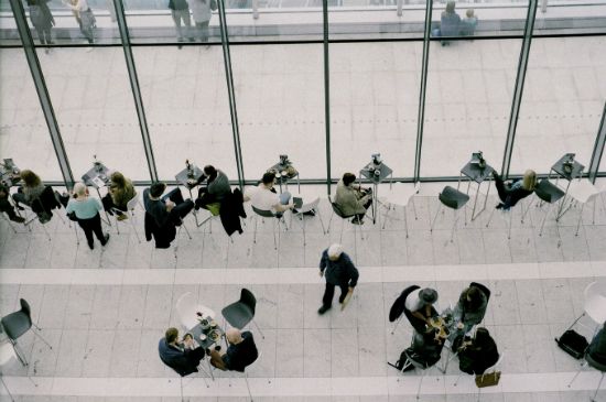 a group of people are sitting at tables in a restaurant .