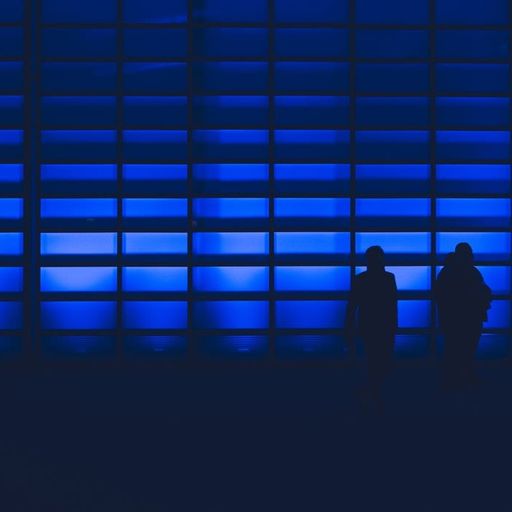 two people are standing in front of a blue wall .