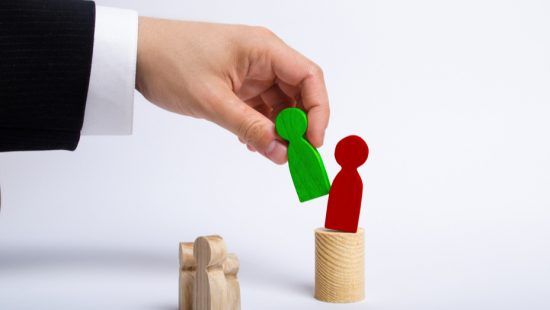 a hand is holding a green stick figure next to a red stick figure .
