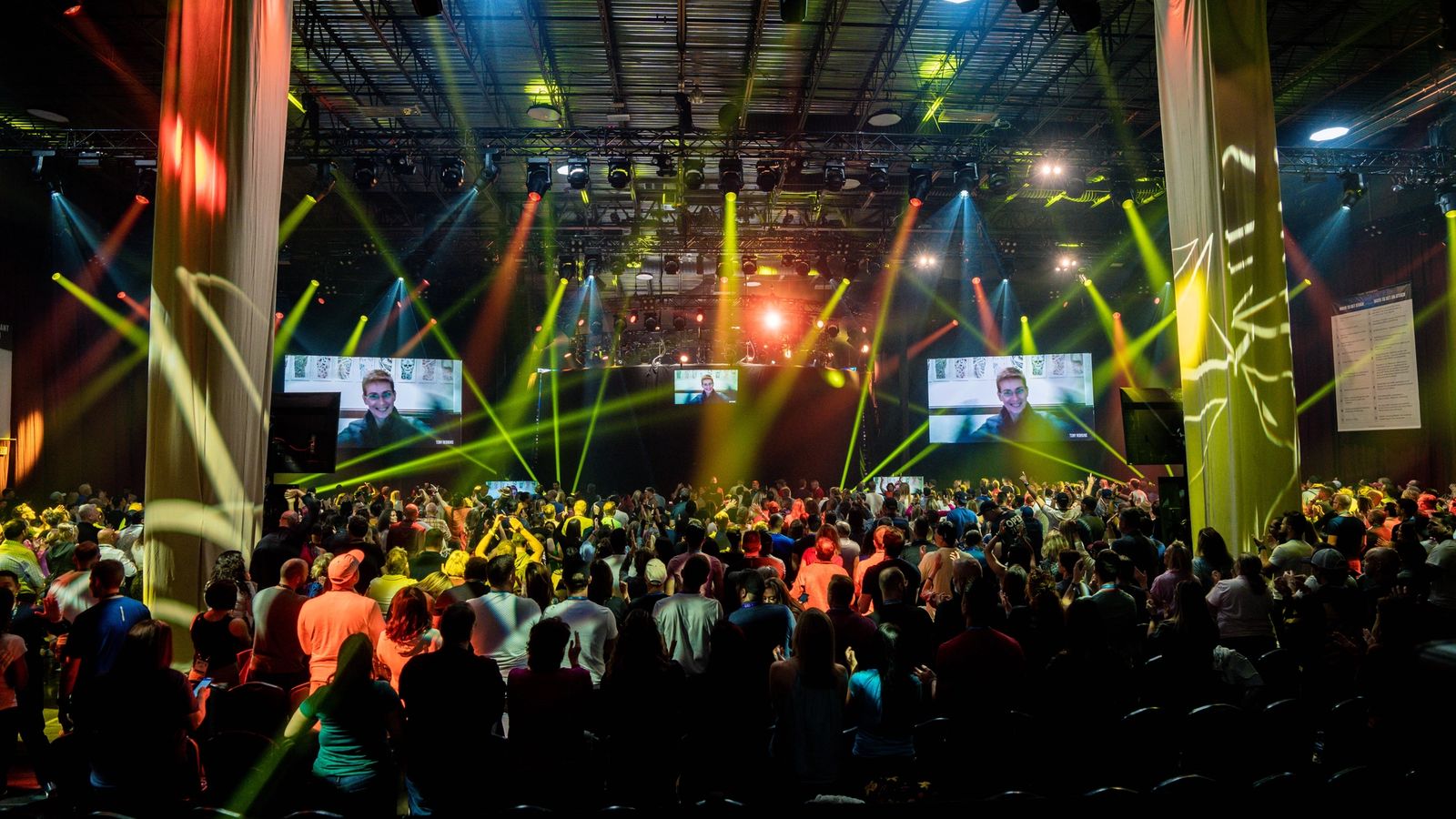 a large crowd of people are gathered in a large room at a concert .