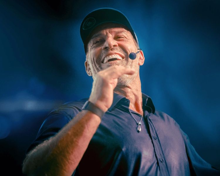 a man wearing a hat and a microphone is smiling .