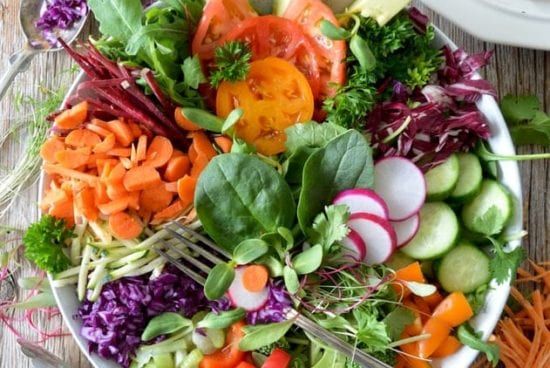 a bowl of vegetables with a fork in it on a table .