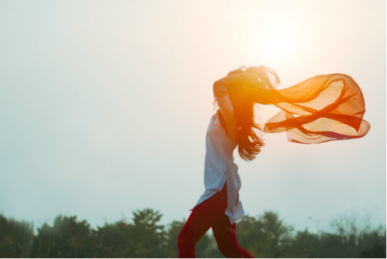 a woman with a scarf blowing in the wind