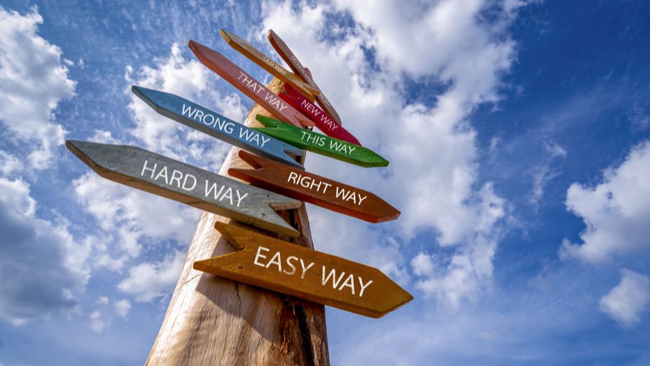 a wooden signpost with arrows pointing in different directions .