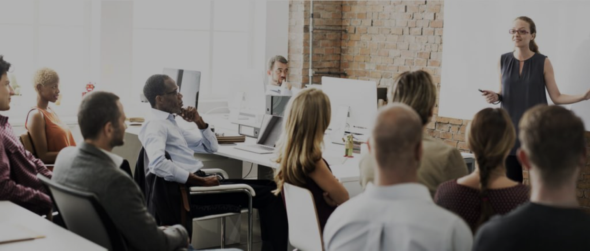 a woman is giving a presentation to a group of people