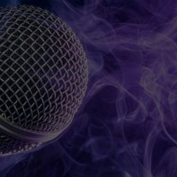 The Mic is Mightier than the Sword closeup image of a microphone with smoke background