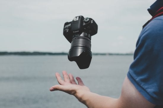 a person is throwing a camera in the air .