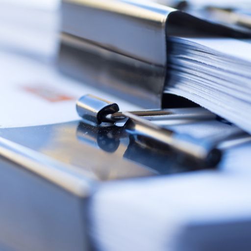 a close up of a stack of binder clips on top of a stack of papers .