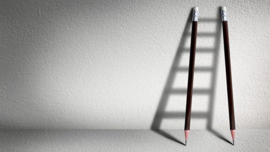 two pencils are leaning against a wall with their shadows casting a ladder .