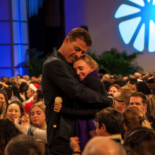 a man and woman are hugging in front of a crowd