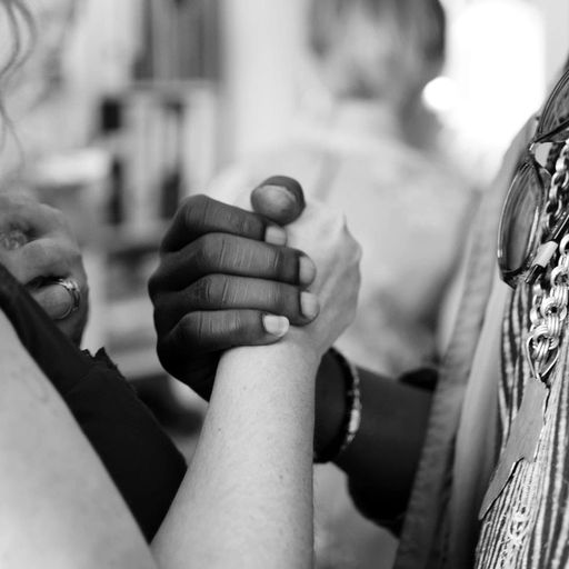 two people are holding hands in a black and white photo .