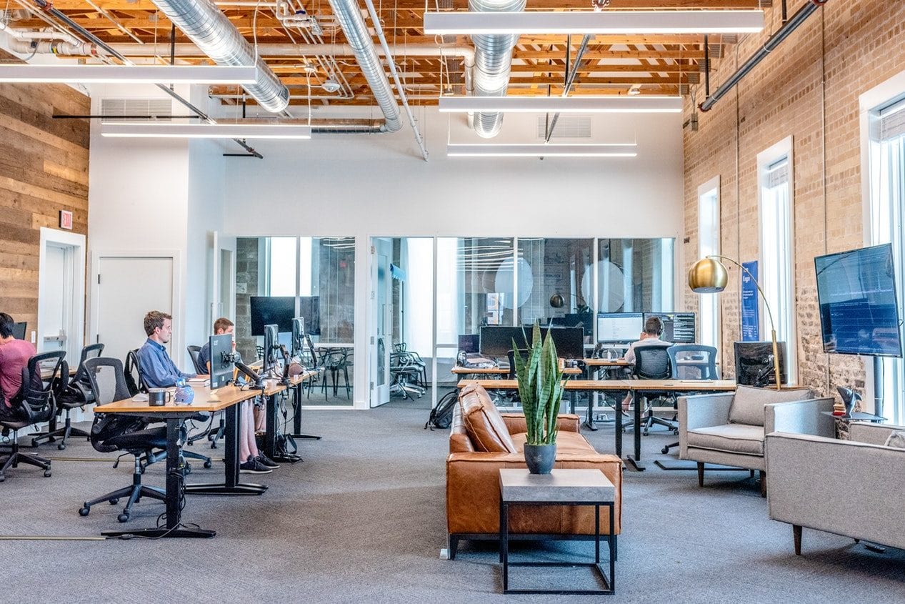a group of people are sitting at desks in an office .