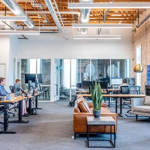 a group of people are sitting at desks in an office .