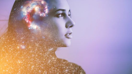 a double exposure of a woman 's face with a spiral of stars coming out of her head .