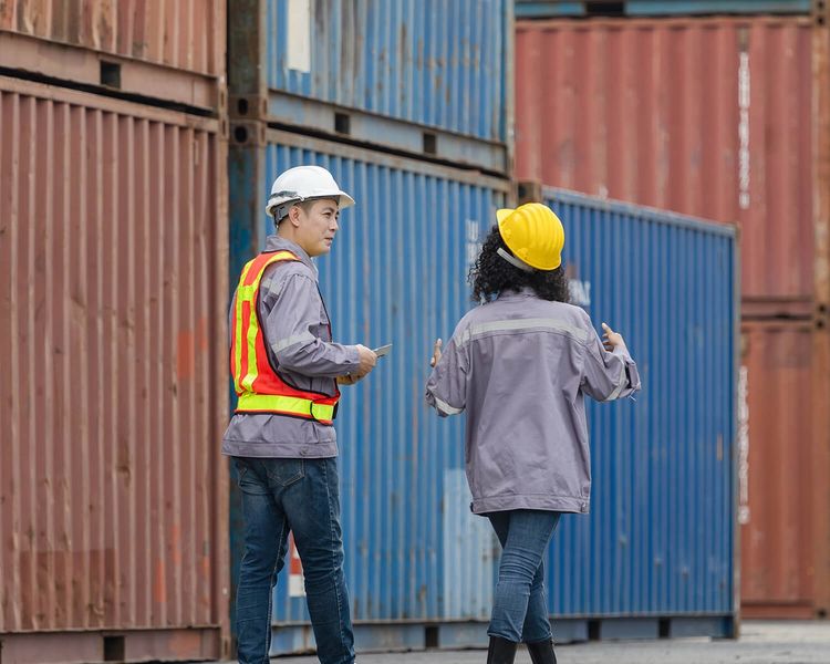 a group of men are sitting around a wooden table having a meeting .