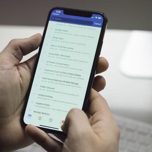 a person is holding a cell phone in their hand .