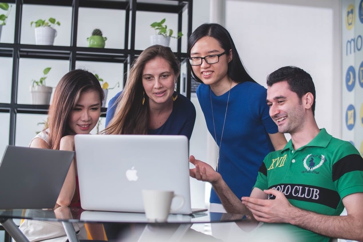 a group of people are looking at a laptop computer .