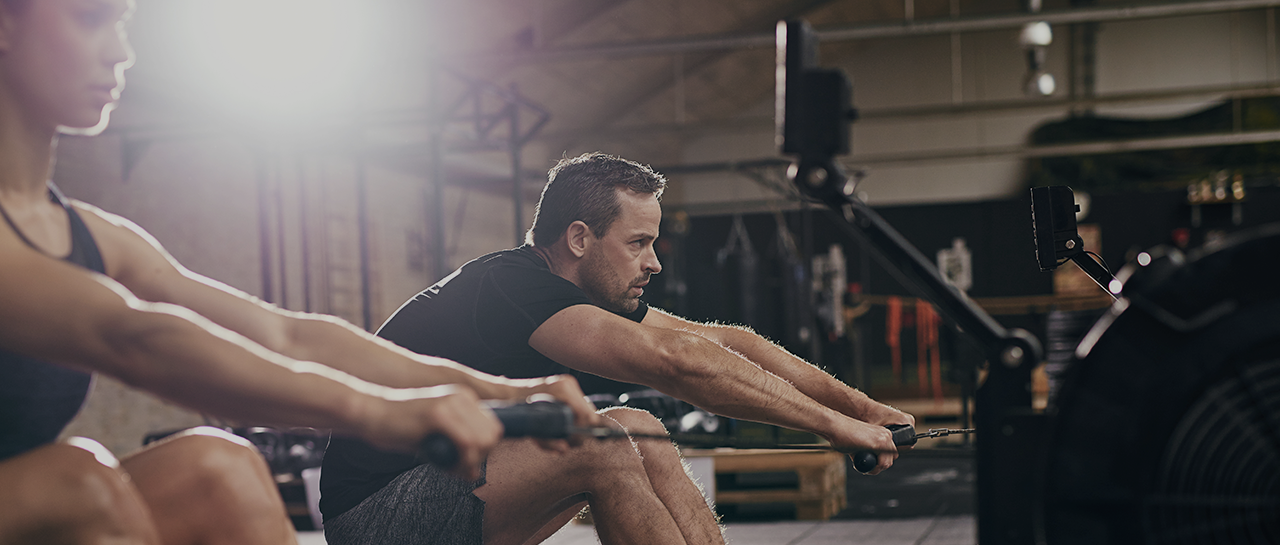 The top biohacks to unleash peak well-being image of man on rowing machine in gym