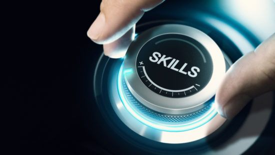 a person is pressing a button with the word skills on it .