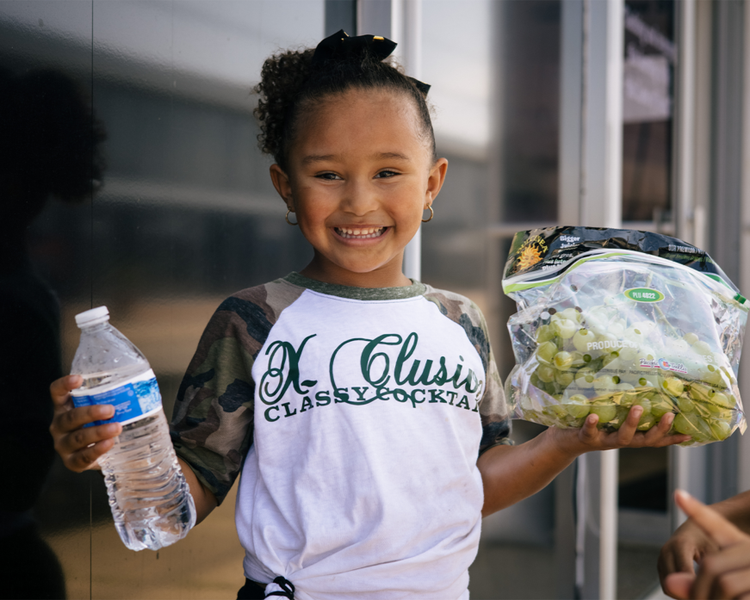 Kid holding bottle water and fruit