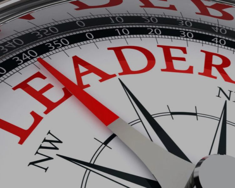 a close up of a compass with the word leader on it .