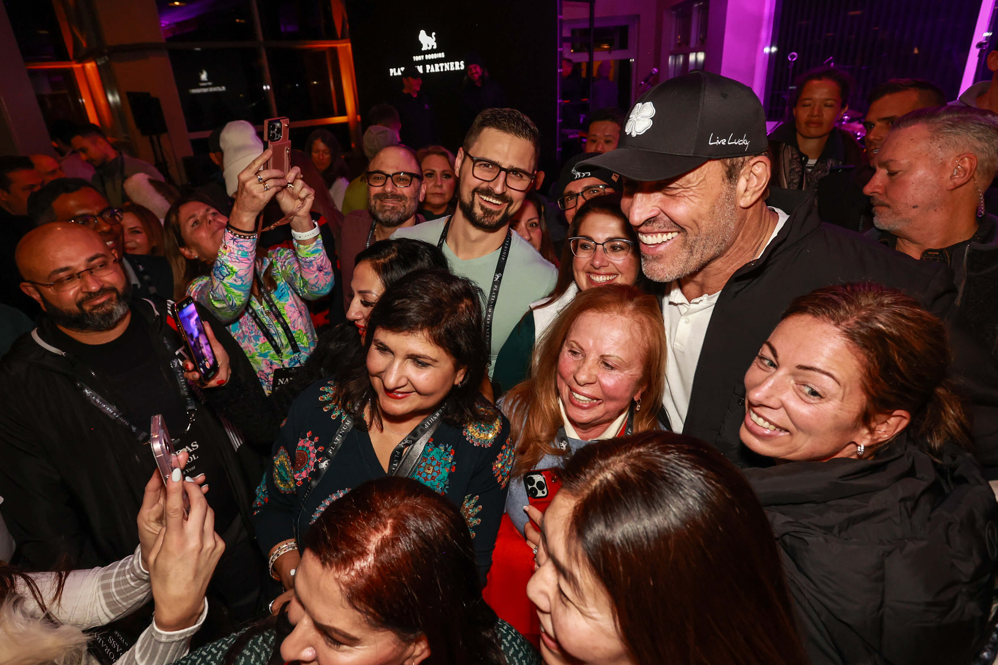 a group of people are posing for a picture with a man in a hat .