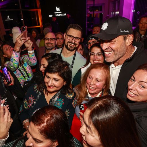 a group of people are posing for a picture with a man in a hat .