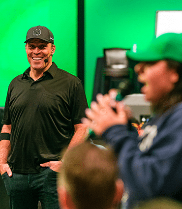 Transform stress into business success image of Tony Robbins watching woman speak in crowd