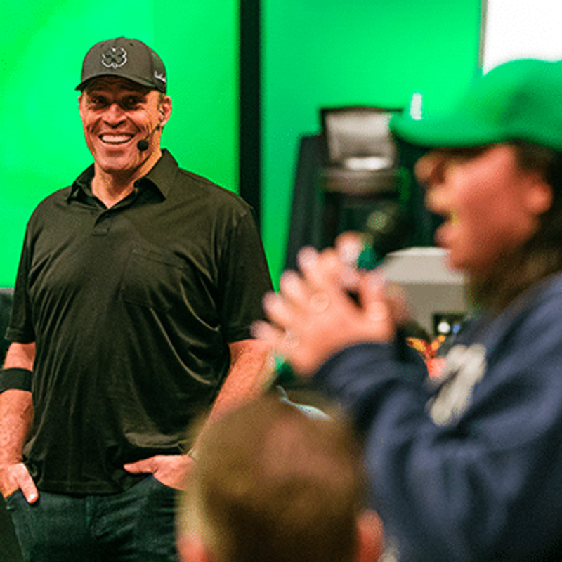 Transform stress into business success image of Tony Robbins watching woman speak in crowd