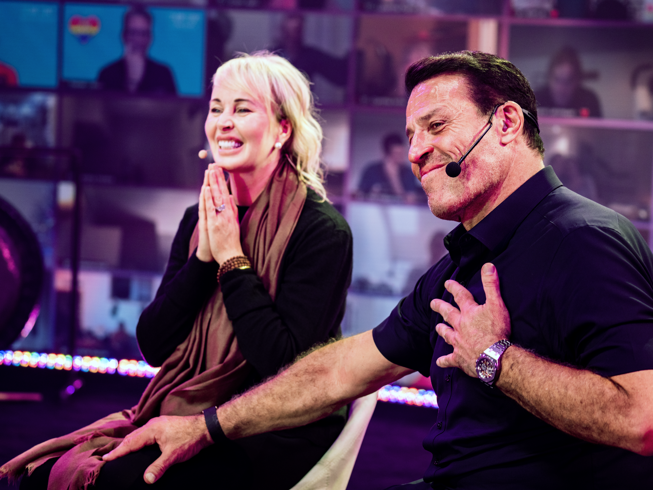 a man with a microphone on his head sits next to a woman