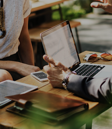 A playbook for entrepreneurs image of man opening laptop at desk with planner