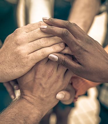 A historic conversation for healing and unity image of a diverse group of people are putting their hands together