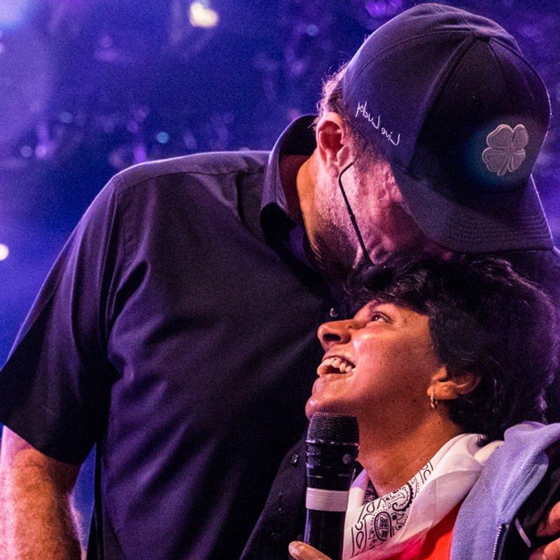 Embracing the gift of grace image of Tony Robbins hugging woman at event