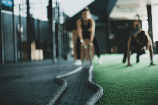 a group of people are doing exercises with ropes in a gym