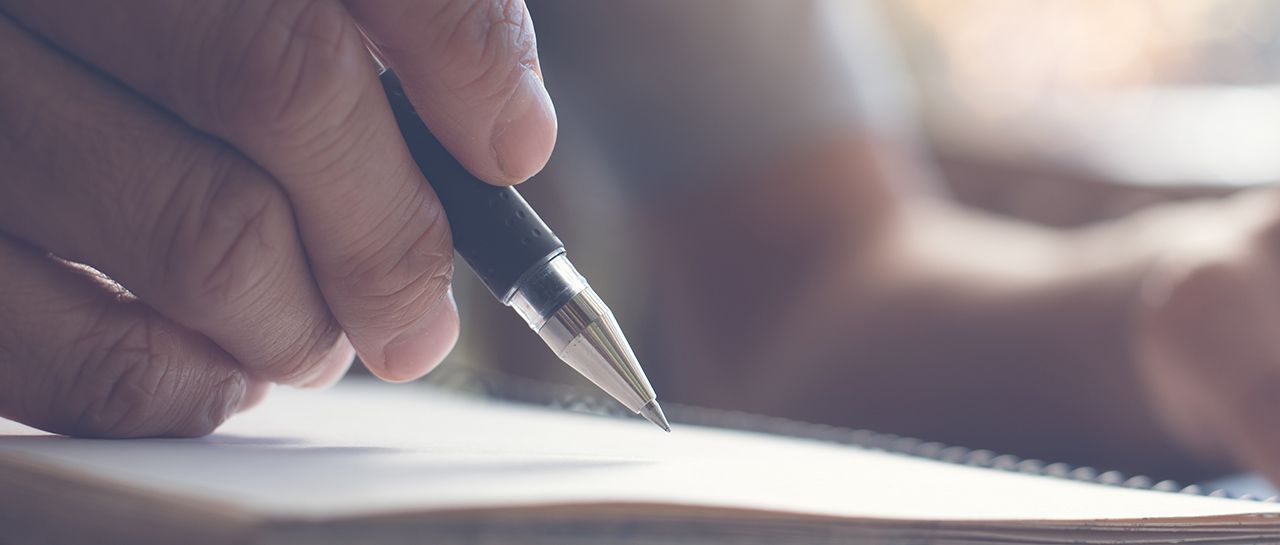 How to take charge of your business image of a person is writing on a piece of paper with a pen .