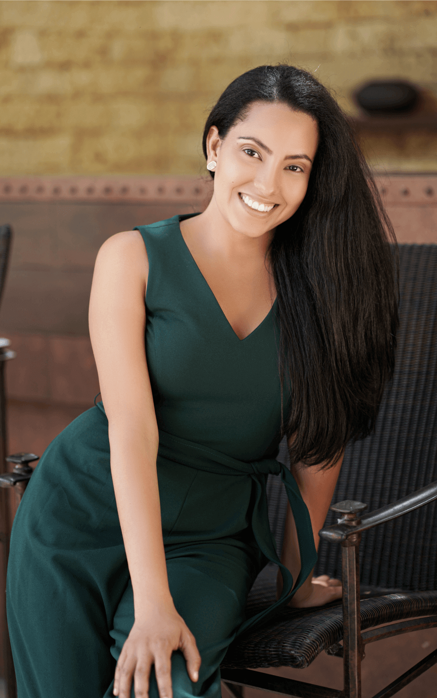 a woman in a green dress sits in a chair