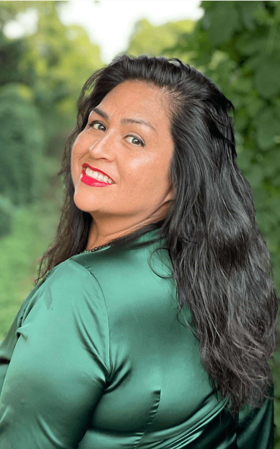 a woman in a green shirt smiles for the camera