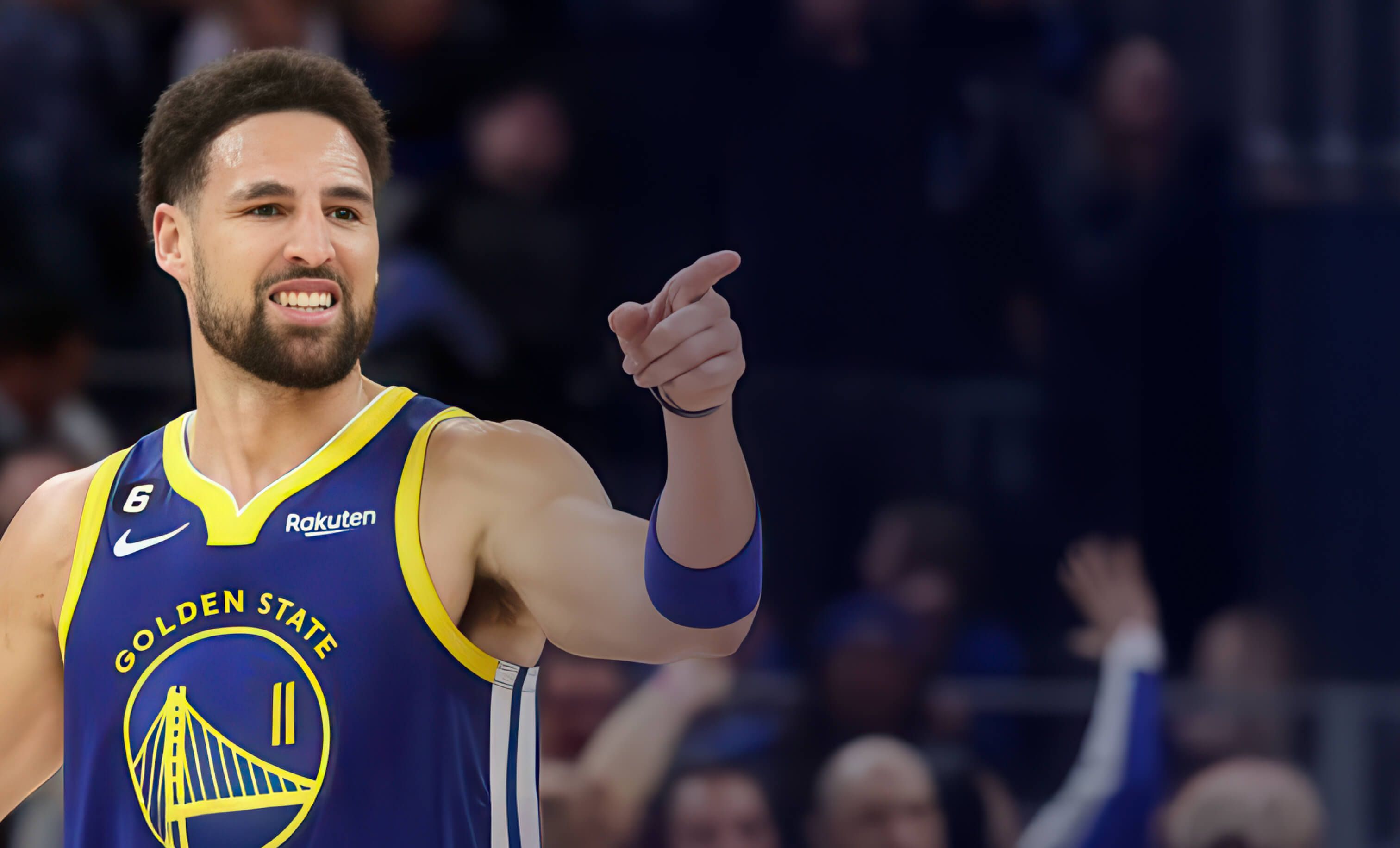 Klay Thompson basketball player for the golden state warriors is pointing at the crowd during a basketball game .