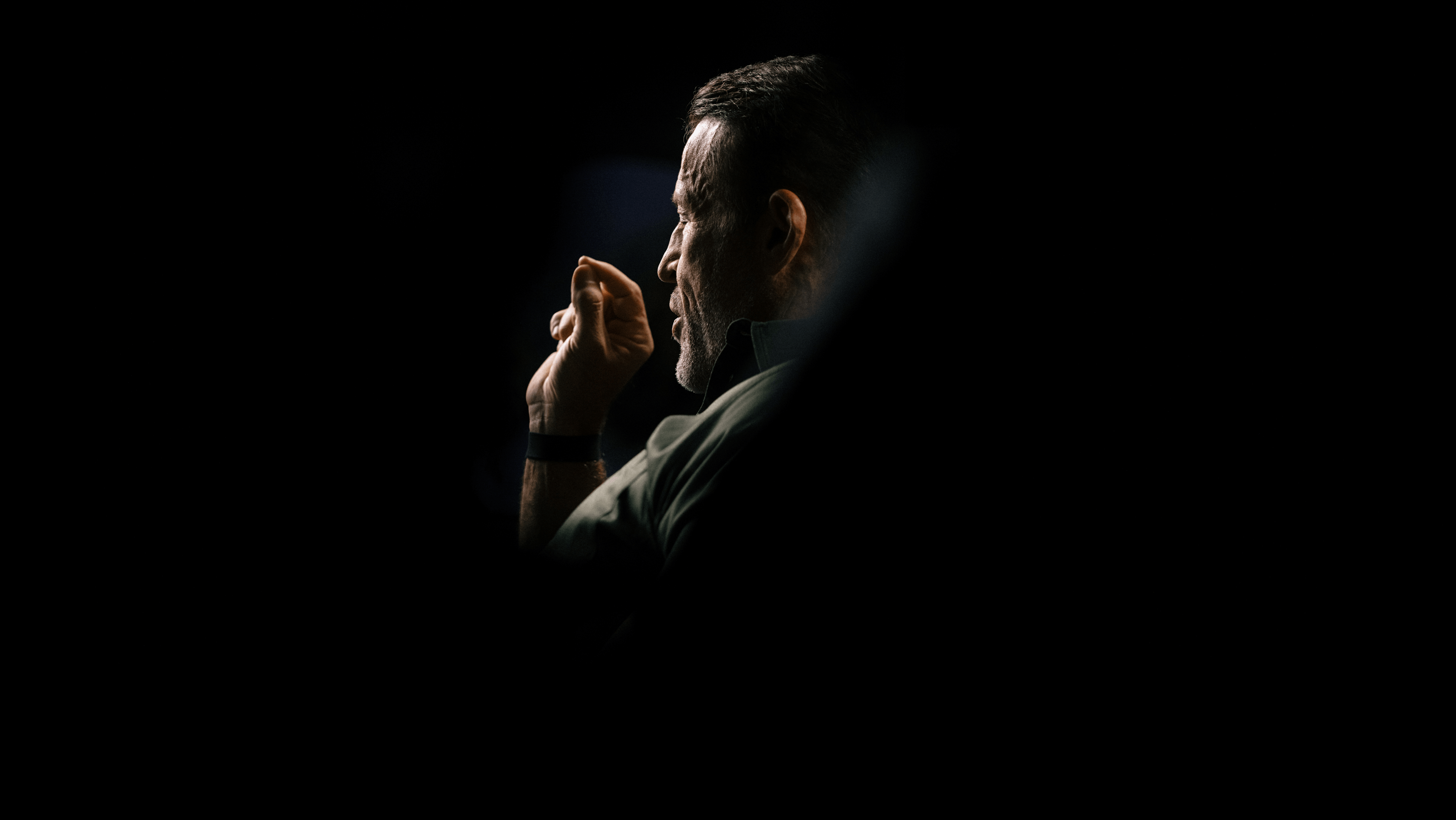 a man is talking on a cell phone next to two cell phones .