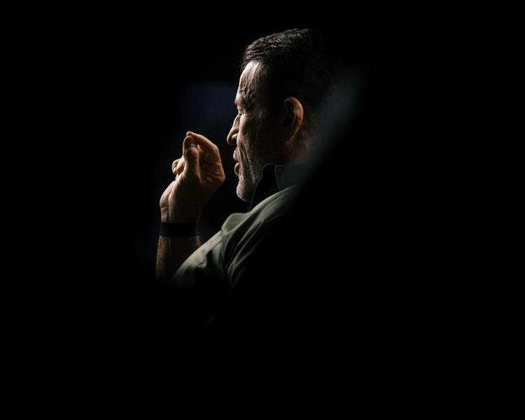 a man is talking on a cell phone next to two cell phones .