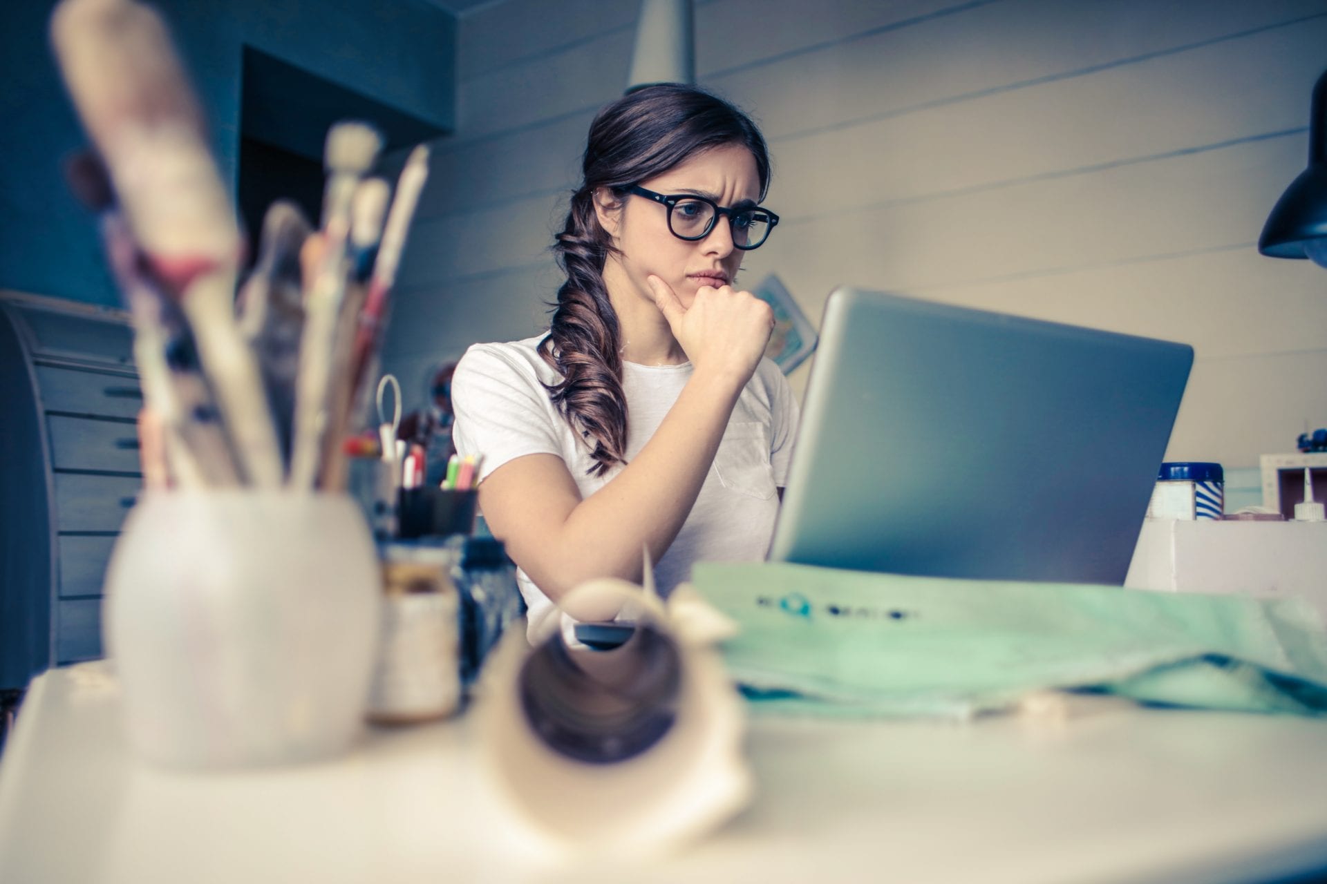 a woman is sitting at a desk using a laptop computer .