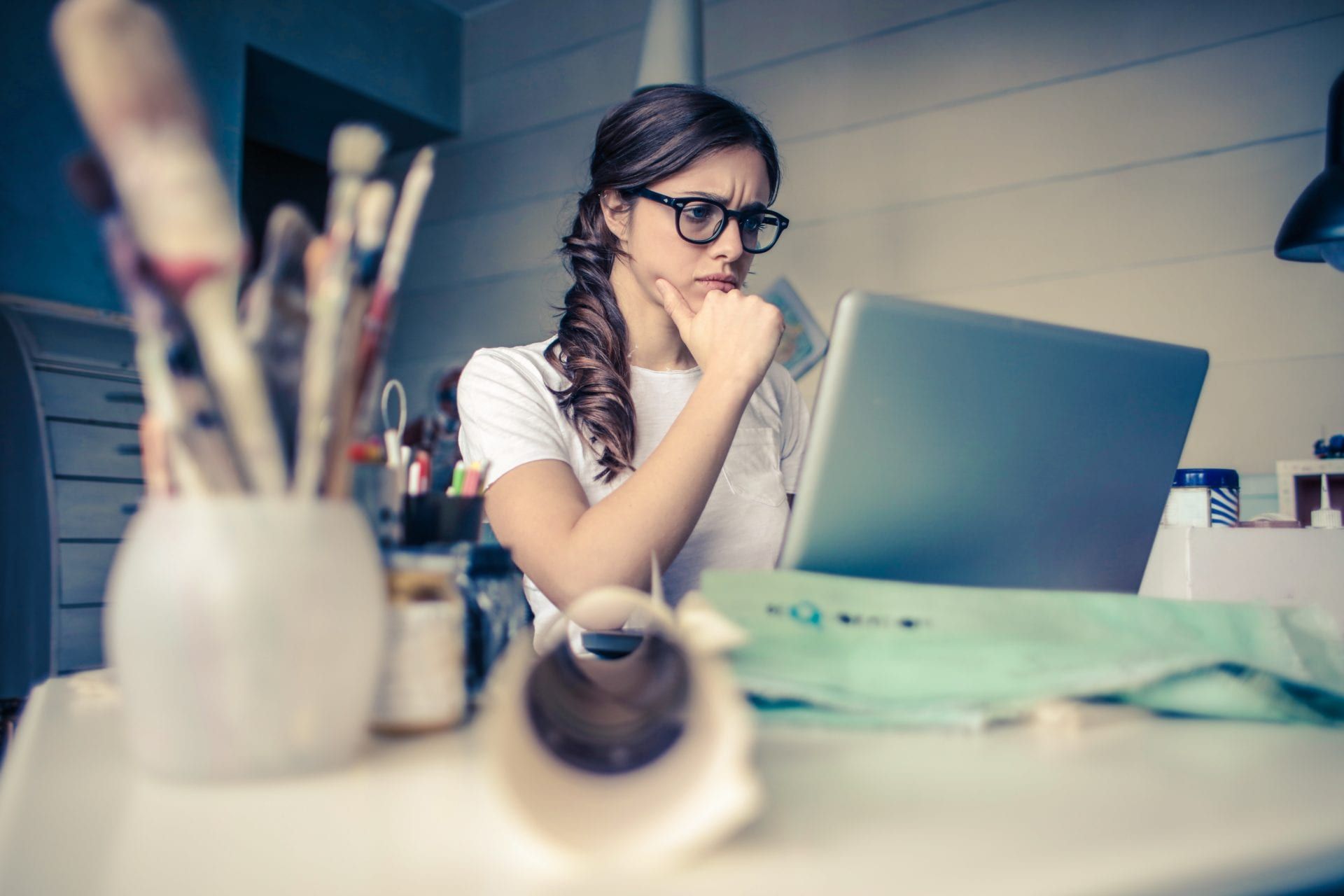a woman is sitting at a desk using a laptop computer .