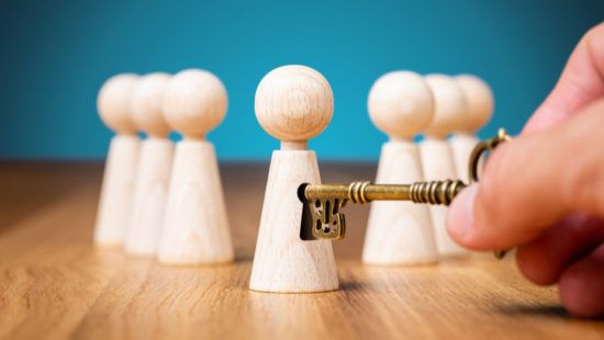 a person is holding a key in front of a group of wooden people .