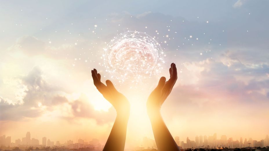 a person is holding a glowing ball in their hands .