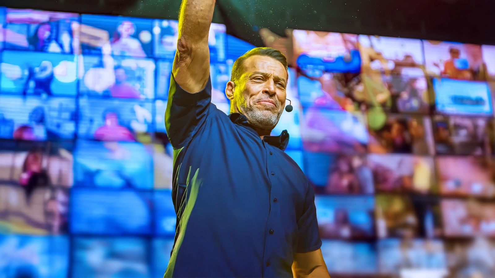 Tony Robbins laughing and clapping in front of a grid of virtual event attendees.