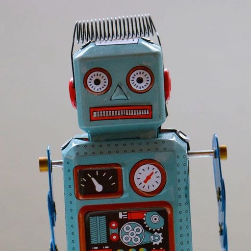 a blue toy robot with a red face is sitting on a table .